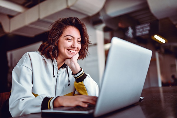 Young woman smiling while working at laptop